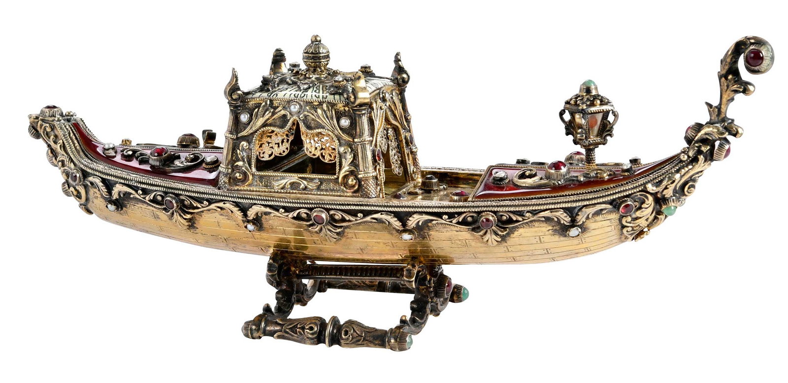 Gilt Silver, Enamel, and Jeweled Gondola: Continental, scroll decoration, burgundy and gilt enamel with cabochon and cut garnets, emeralds. and pearl accents, unmarked, test .925 fine, 25.39 oz. T. gross weight, 4-1/2 x 11 x 3 in. Provenance: