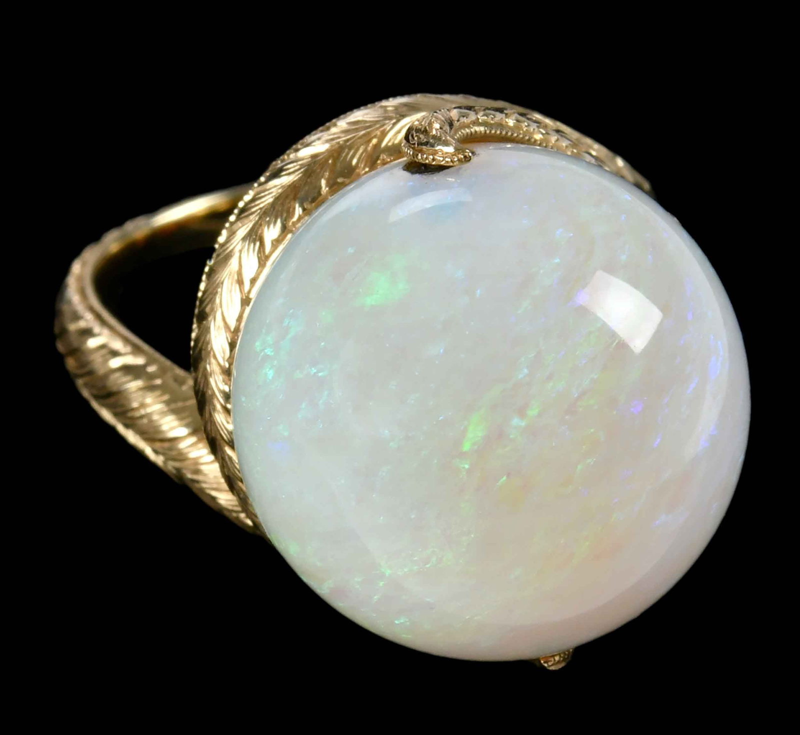 14kt. Tremonti Rotating Spherical Opal Ball Ring: large opal, 16.0mm, approx. 23.25ct., hand engraved, marked "14K, Tremonti, OP23.25", yellow gold, 7 ring sz., 12.4 g Provenance: Private Collection Note: Brunk Auctions makes no warranty or guarantee