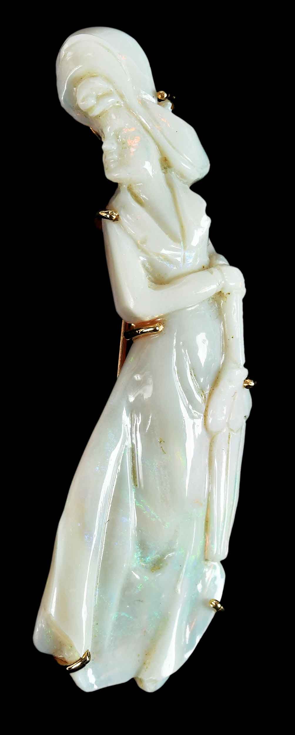 14kt. Carved Opal Lady Figure Brooch: white opal, 2-1/2 in. length, marked "K14", yellow gold, 8.1 g Provenance: Private Collection Note: Brunk Auctions makes no warranty or guarantee regarding any metal stamps, maker's marks, and/or meta