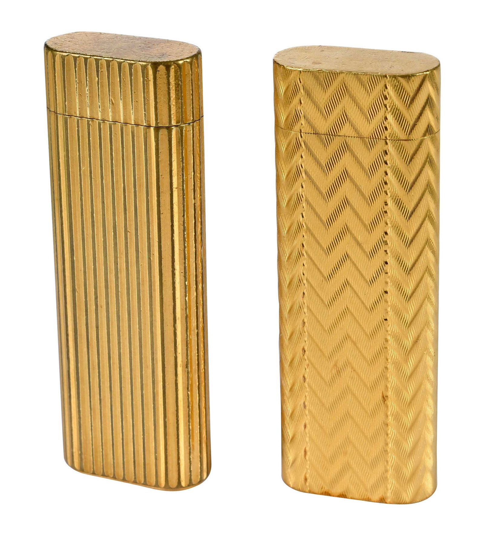 Two Cartier Gold Plated Lighters: oval ribbed, yellow gold plated, marked "Cartier, Paris, 126971T, Swiss Made", 2-3/4 in. length; chevron finish, yellow gold plated, marked "Cartier, Paris, C79118", 2-5/8 in. length Provenance: Priva