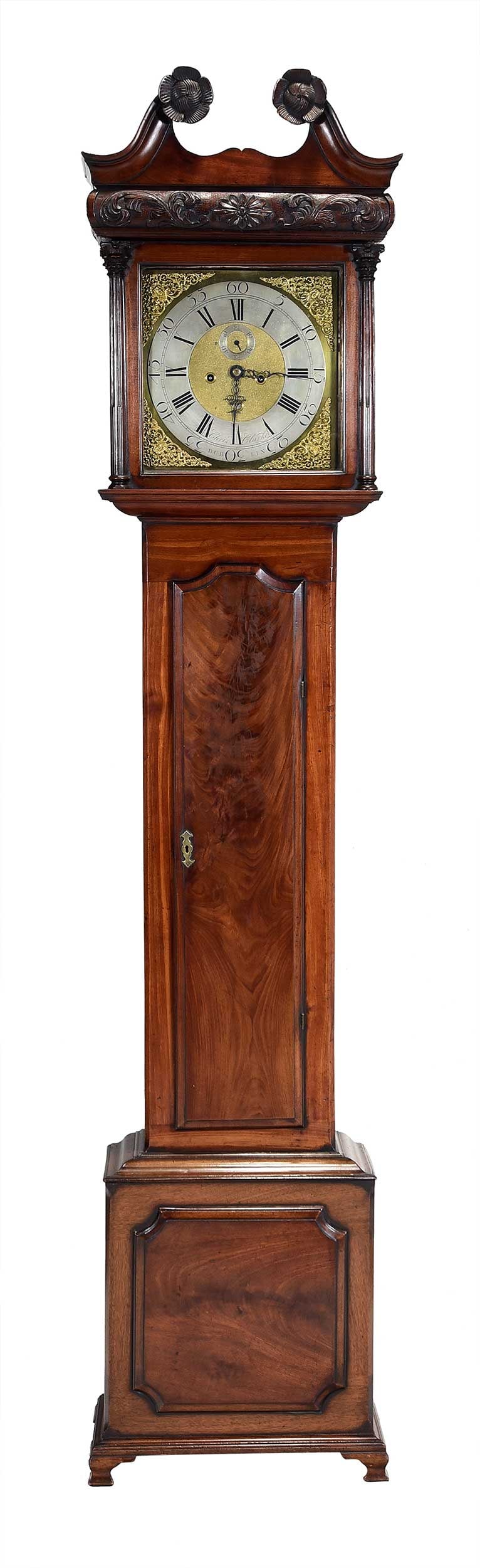 Irish George III Figured Walnut Tall Case Clock, Chris Clarke: Dublin, 18th century, broken scrolled pediment bonnet with large rosettes, floral and foliate carved frieze, original glass, dial with figural applied brass and incised with "Chris Clarke DUBLIN",