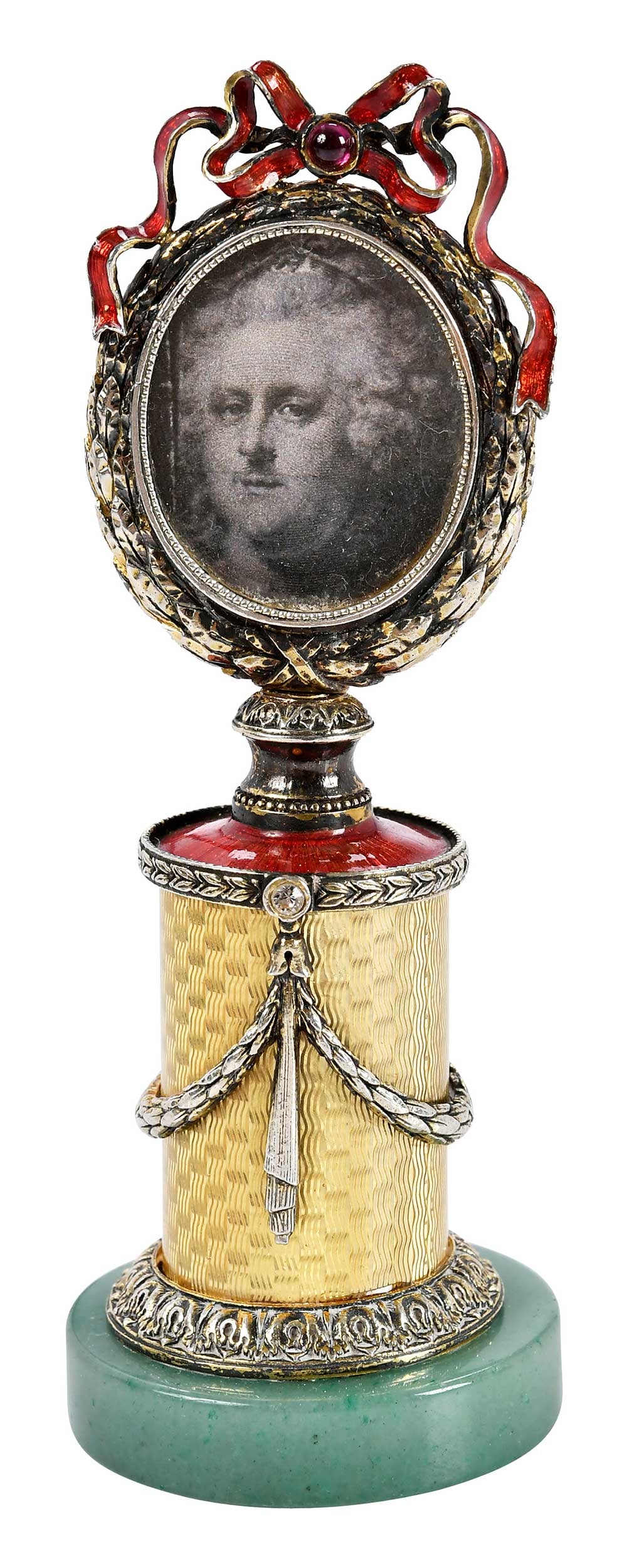 Faberge Style Miniature Picture Frame: 20th century, yellow and red enamel base with round wreath from frame, topped with red enamel bow, accented with diamonds and garnet, mounted on an aventurine base, unmarked, test.961 fine (with