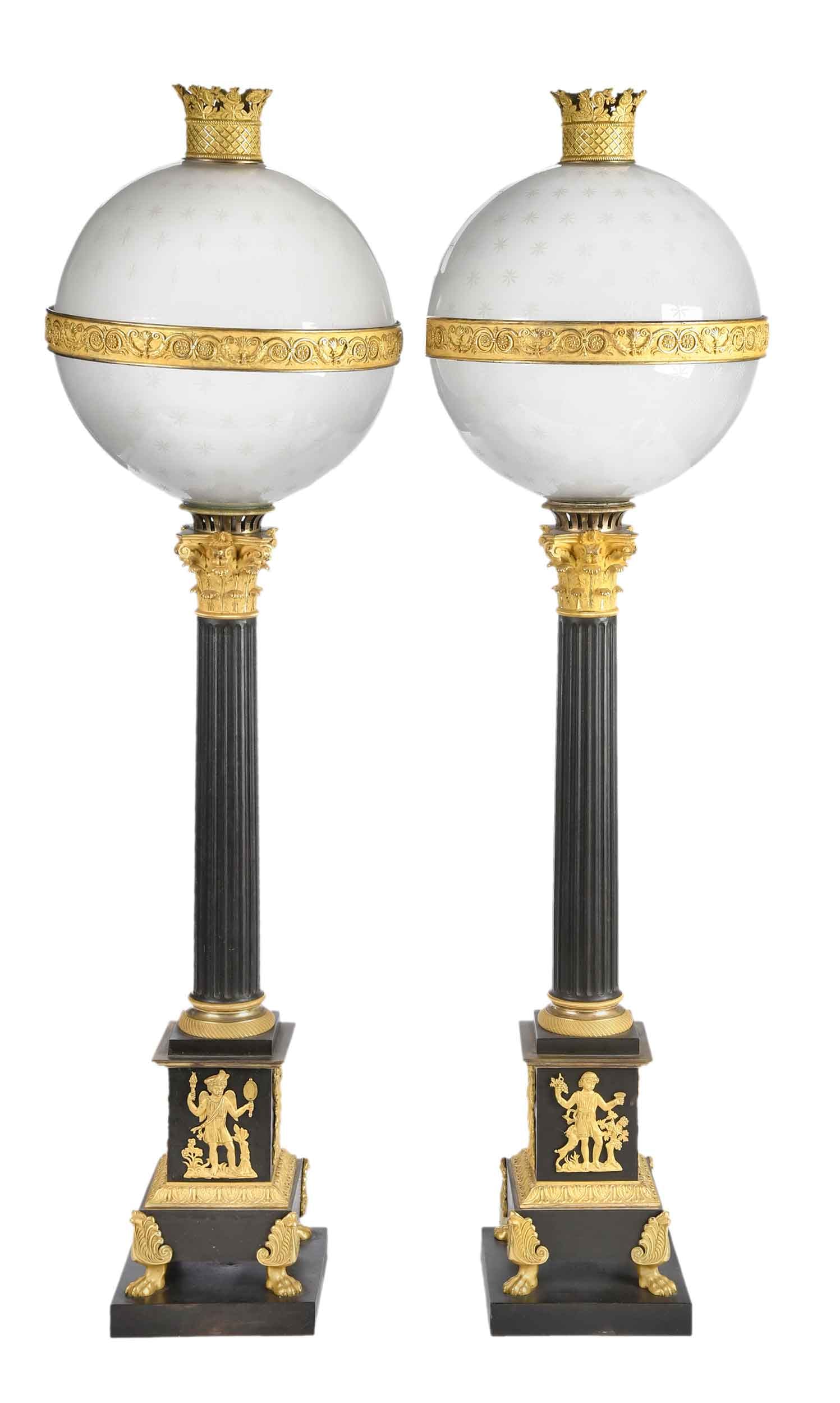 Pair Of French Ormolu and Patinated Bronze Carcel Lamps: early 19th century, Corinthian columns on paw footed bases, etched glass globes are comprised of two halves each, wired for electricity, each 38-1/2 x 10-3/4 x 1-3/4 in. Provenance: The Delany Collect