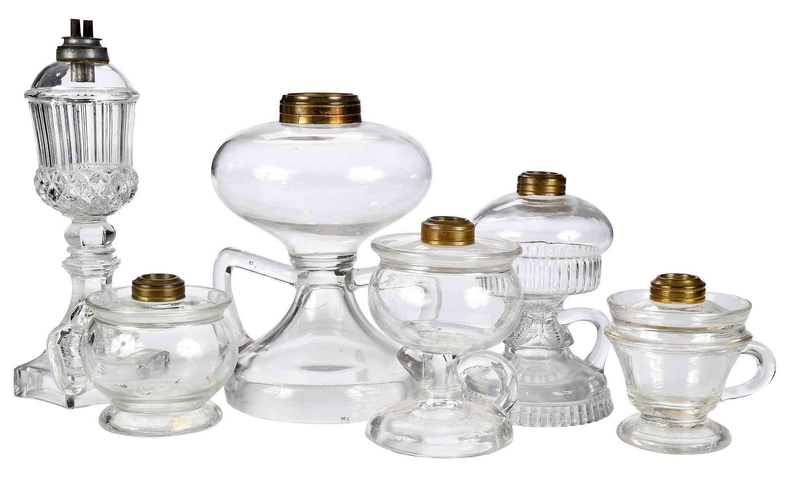 Six 19th Century Pressed Glass Oil Lamps: varying forms including one whale oil lamp, largest 9 x 6-1/2 x 6-1/2 in. Provenance: (four examples) Catherine M. V. Thuro Collection (labels); The Ray J. and Anne K. Groves Collection