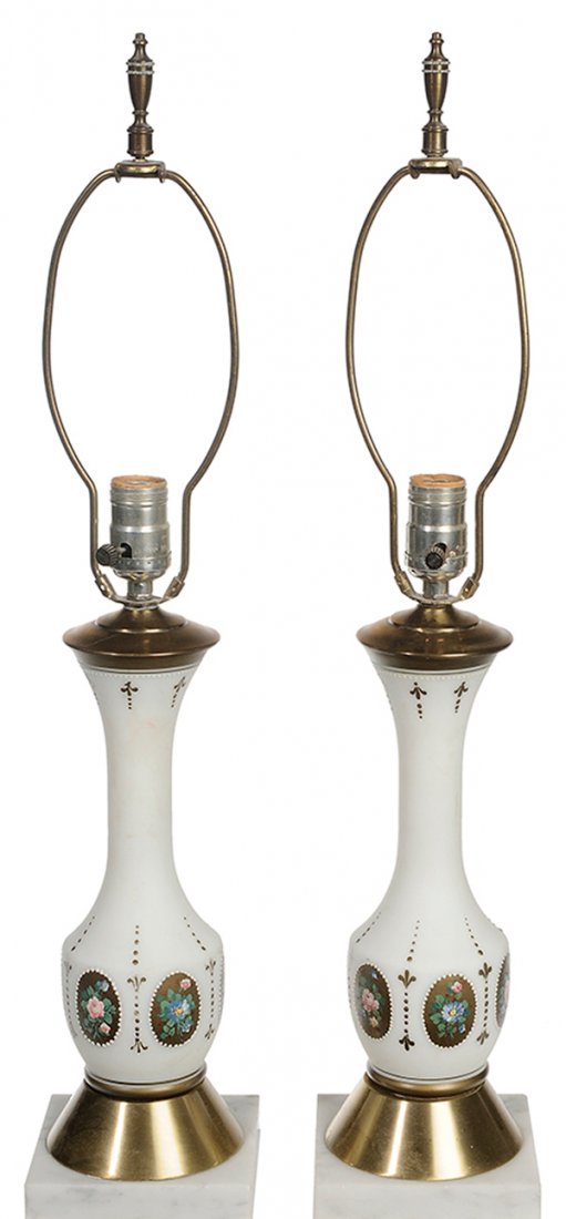 Pair Gilt and Hand Painted White: Glass Vases Converted to Table Lamps French late 19th/20th century, oval banded medallions with hand painted floral devices flanked by draped flag, brass tapering bases on white marble bases, 13-1/2 i