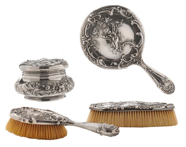 Cupid Sterling Dresser Set: American, late 19th/early 20th century, all with cupid in clouds, scroll and floral borders, Mauser Manufacturing, one with monogram, 3-1/2 x 4-3/4 in. covered jar, hand mirror, two brushes, dents, li