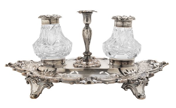 English Silver Standish: Sheffield, 1852, openwork cartouche form base with scroll feet, two cut-glass ink bottles with silver lids, central taper holder, all with matching marks, marks for Hy Wilkinson & Co., no monogram, .9