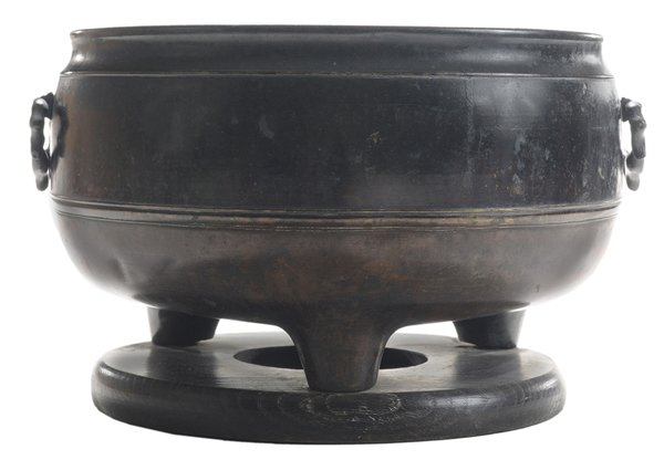 Bronze Tripod Brazier: Chinese, late 19th century, overhung interior rim, two applied floral-form handles, tripod base, 7-1/2 x 11-3/8 in., circular wooden stand, good condition. Provenance: Smith Estate, Missouri