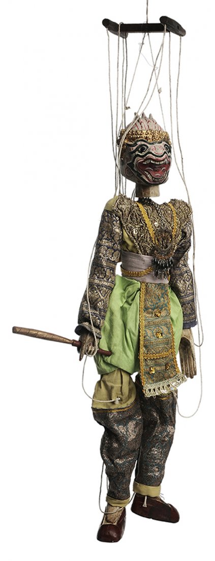 Carved and Painted Marionette: Thai, 20th century, hand-painted [papier mache] head with gilt headdress, devilish expression with open mouth, silk and jeweled clothing, carved and painted hands carrying a club, the hinged wooden bo