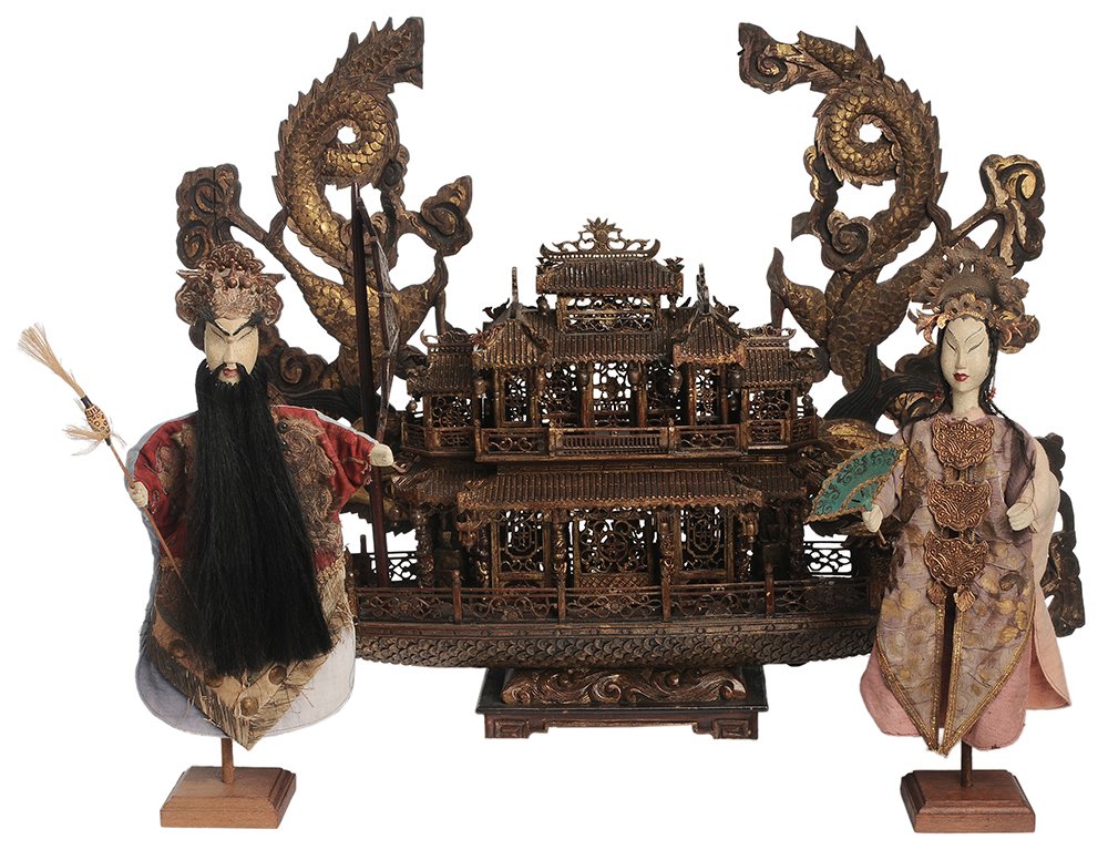 Finely Carved Imperial Dragon Boat: Model, Two Imperial Puppets, Two Architectural Fragments Chinese, 20th century: bamboo and wood-carved dragon-form enameled and gilt-decorated boat, bow fitted with the head of a dragon holding a pear