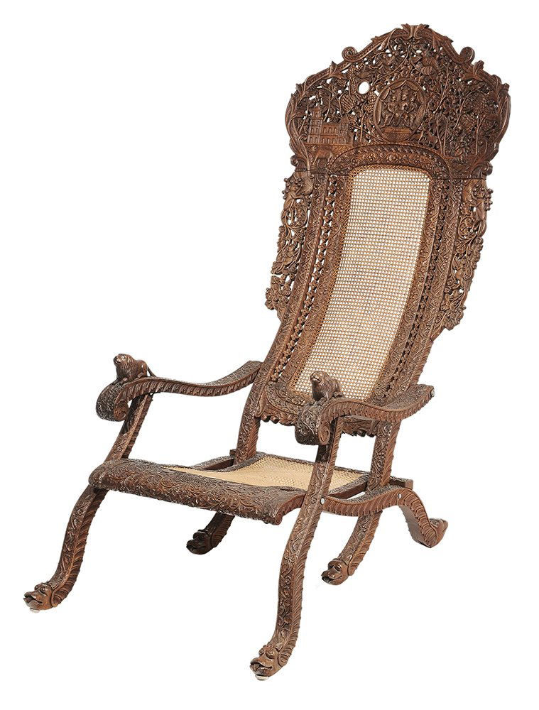 Anglo-Indian Elaborately Carved: Folding Plantation Chair probably Indian, late 19th century, elaborately carved frame set with figures, monkeys, lions and stylized foliate decoration, caned seat and back, carved lion hand grips with