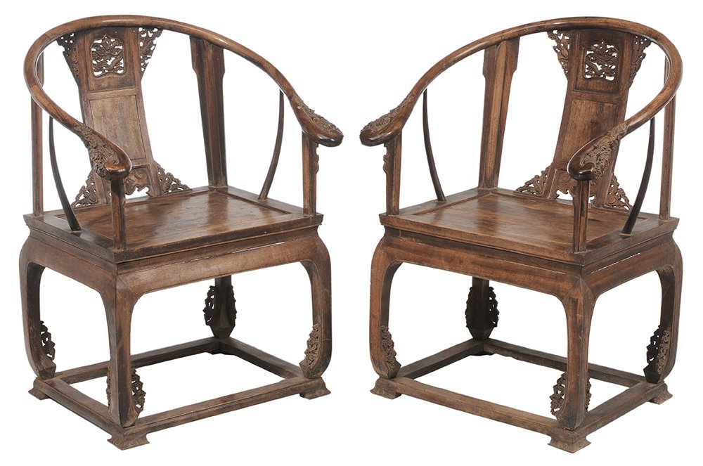 Pair Chinese Carved Hardwood: Open-Arm Chairs each with finely carved dragon and bat motifs, carved hand grips, 39-1/2 x 28-1/2 x 22-1/2 in., generally good condition with scattered surface wear, stains and finish losses, minor ch
