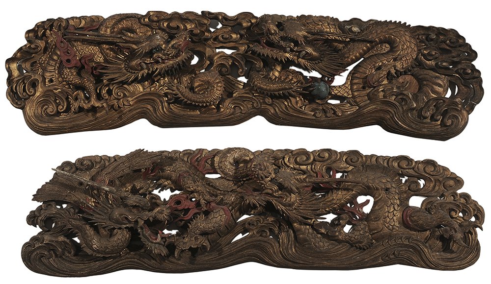 Pair Chinese Carved, Polychromed: and Parcel-Gilt Dragon Plaques late 19th/early 20th century, each in the form of two intertwined dragons with inset eyes, polychromed elements with gilding overall, 61 x 16 x 2 in., scattered cracks a
