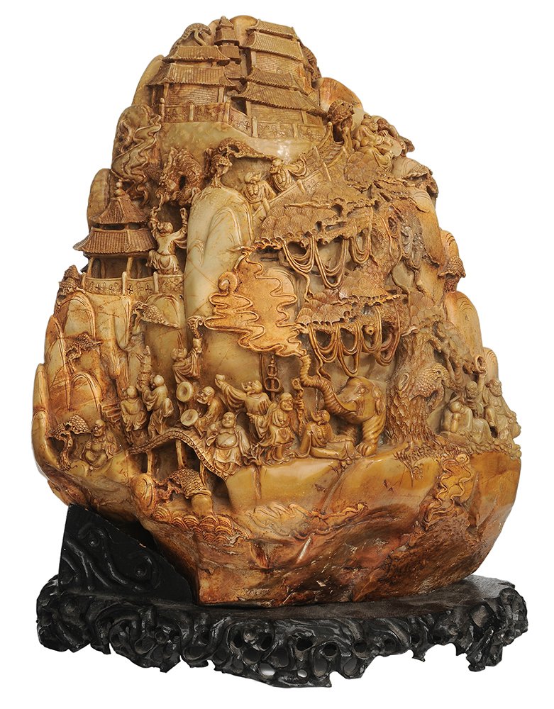 Large Figurally Carved Soapstone: Boulder Chinese, 20th century, ocher to gray color, elaborately carved figures, buildings and elephants on both sides, 21-1/2 x 16-1/2 in., modern carved base generally good condition, natural cracks 