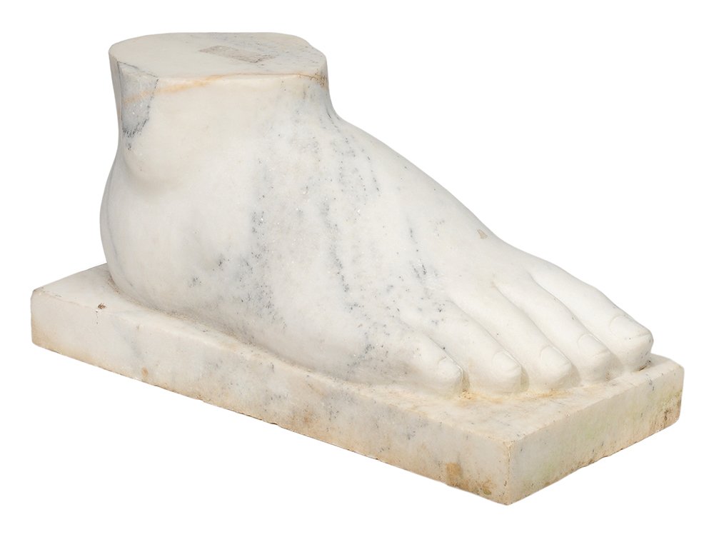 Carved Marble Foot in the Antique: Style modern, a right foot in variegated white marble set on a rectangular plinth, 10 x 20 x 8-3/4 in., minor surface stains including crack and stain at top as made. Provenance: Collection of Dr. L. 
