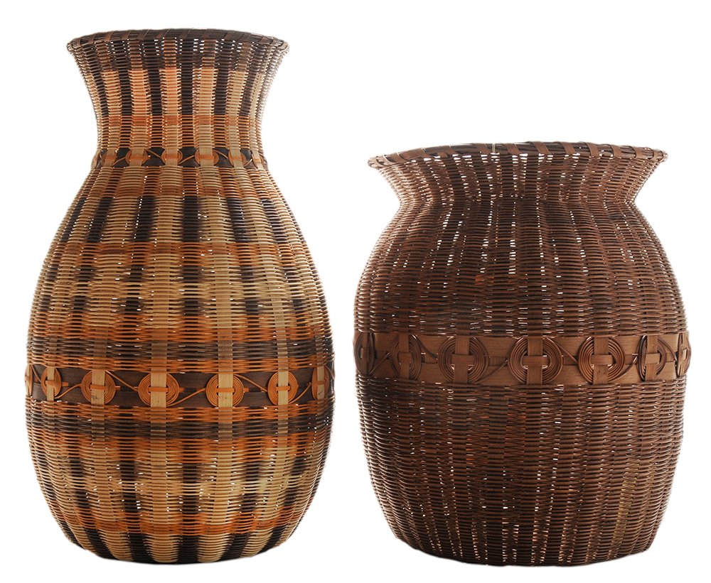 Two Cherokee Honeysuckle Wastebaskets: each with white oak ribs and butternut dyes, one made by Lucy George, 1972, 14-1/2 in.; one made by Joyce Taylor, 18 in., both with Qualla Arts & Crafts Mutual tag, both in good condition. Provenance: