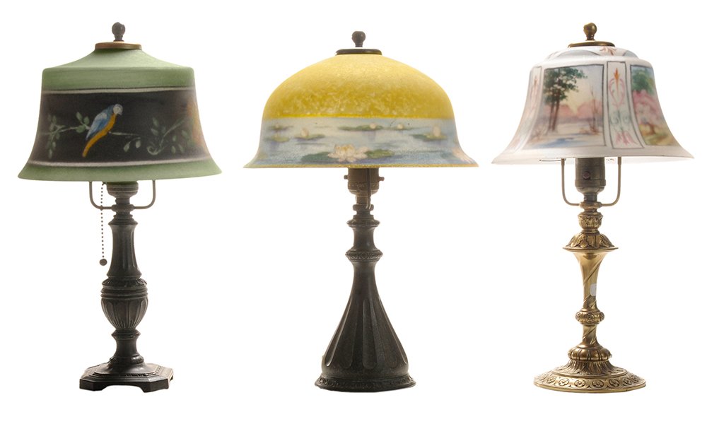 Three Pairpoint Reverse-Painted: Boudoir Lamps American, early 20th century: one with bell-shaped shade with bird and floral banding on green ground and signed "The Pairpoint Corp.-N", lacquered brass vasiform base, "Pairpoint D3048"