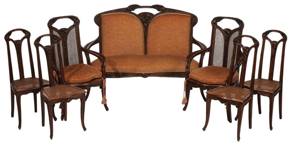 Very Fine Louis Majorelle Art Nouveau: Carved Walnut Seven-Piece [Ombellifleurs] Salon Suite French, circa 1900, comprising a finely carved and upholstered settee, 45 x 61-3/4 x 23-1/2 in.; two matching caned armchairs set with loose cushi