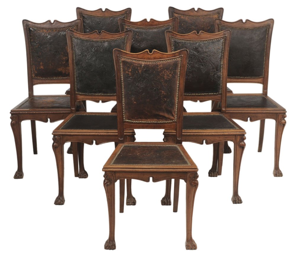 Set of Eight Art Nouveau Carved: Walnut and Leather-Upholstered Dining Chairs French, circa 1900, each with leaf-carved knees and stylized root-carved feet, original leather upholstery with leaf and floral tooled decoration and brass