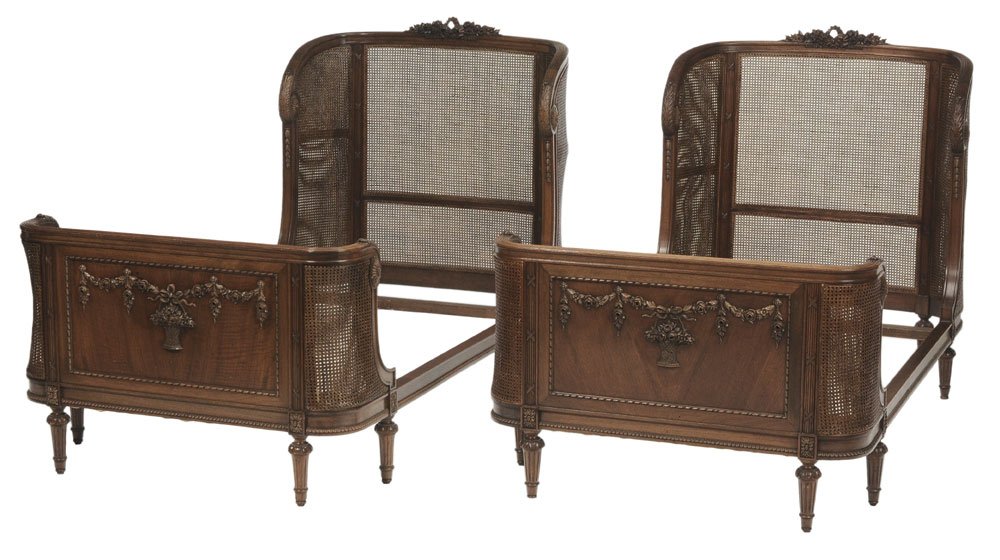 Pair Louis XVI Style Carved Walnut: and Caned Bedsteads 20th century, floral and ribbon-carved crests, caned curved head and footboards, 48-1/2 x 43 x 85-1/2 in.,