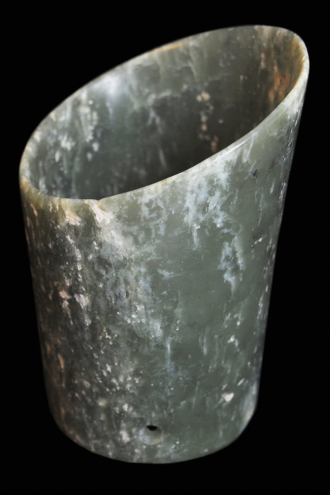 Horse Hoof Form Jadeite Hair Tube: Chinese, carved celadon-green and white speckled jadeite hair tube, drilled holes at sides, 3-1/2 x 2-3/4 in., internal fracture visible at left side and rear center top, natural inclusions overall