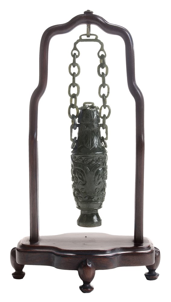 Finely Carved Spinach Jade Hanging: Vase on Hardwood Stand Chinese, covered vase with loose ring handles, body with stylized flowers and scrolling devices with large Buddhist symbol, platform base, link chain and hanger, 8-1/4 in. with 