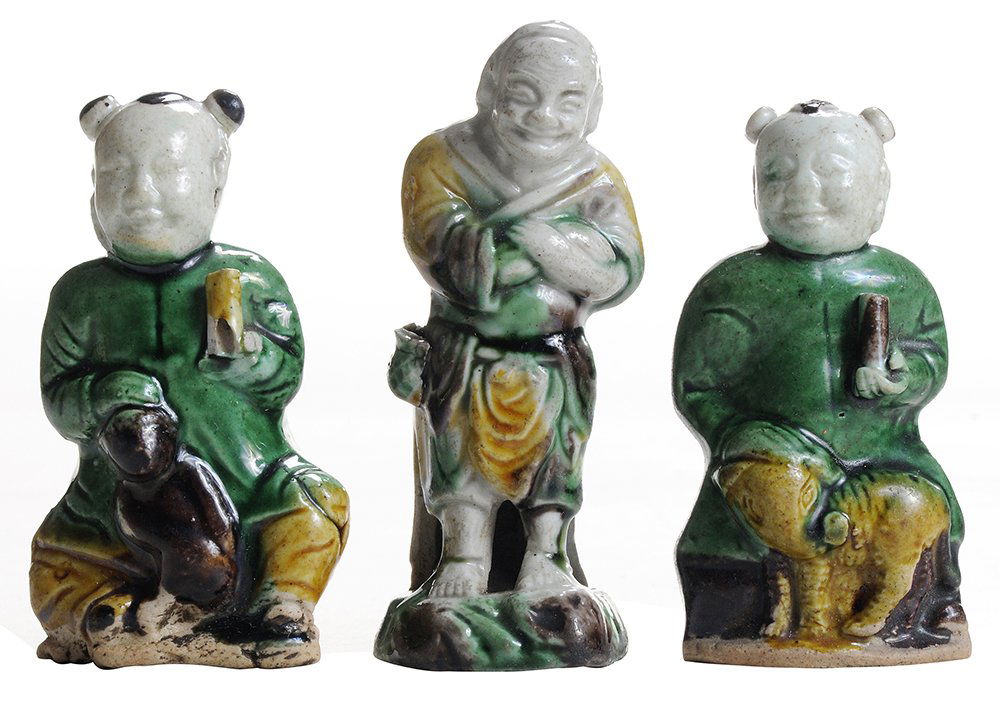 Group of Three Early Chinese: Ceramic Figures probably Kangxi period, each glazed earthenware figure decorated in shades of green, brown and mustard, 3 in., one kneeling figure with chip and loss at scroll,one with chip and loss a