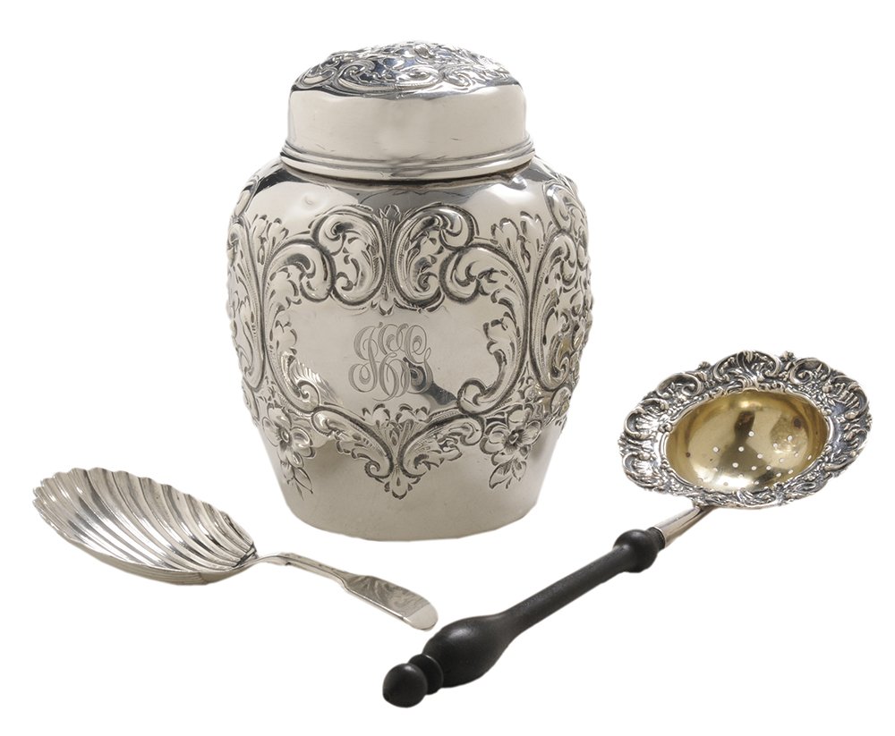 Three Silver Tea-Related Items: including sterling tea canister, floral and scroll decoration, monogram, 4 in.; sterling tea strainer, turned wooden handle, monogram, 6-3/4 in.; Scottish silver tea caddy spoon, shell form bowl, mark