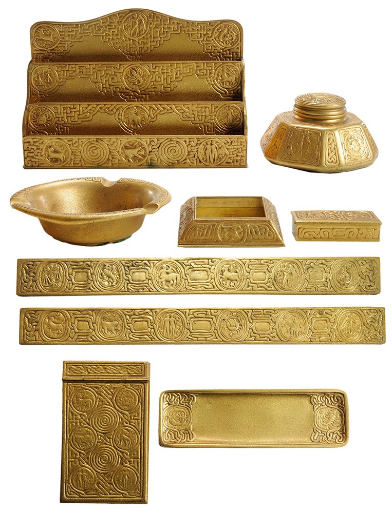 Tiffany Studios Zodiac Pattern Partial: Desk Set American, early 20th century, including hexagonal inkwell with glass inset (shape 1072), pair of blotter ends (988), stamp box (802), pen tray (1000), letter holder (1030), memo cover (1090),