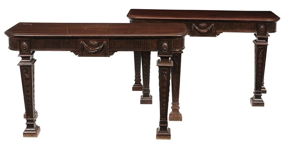 Pair Edwardian Carved Mahogany Pier: Tables British, late 19th/early 20th century, each with fluted and swag-carved frieze, bellflower-carved tapered square legs, dovetailed frames, 34-5/8 x 58-1/2 x 20 in., generally good condition, som