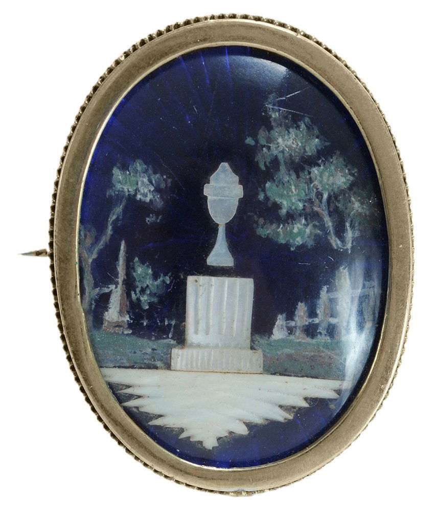 Victorian Memento Mori Brooch: foil memorial scene under blue glass with mother of pearl urn and plinth, bezel-set glass cover with gold metal frame, 1-5/8 x 1 in., tarnish, grime, dents, scratches, glass loose in mount. Notes: Bru