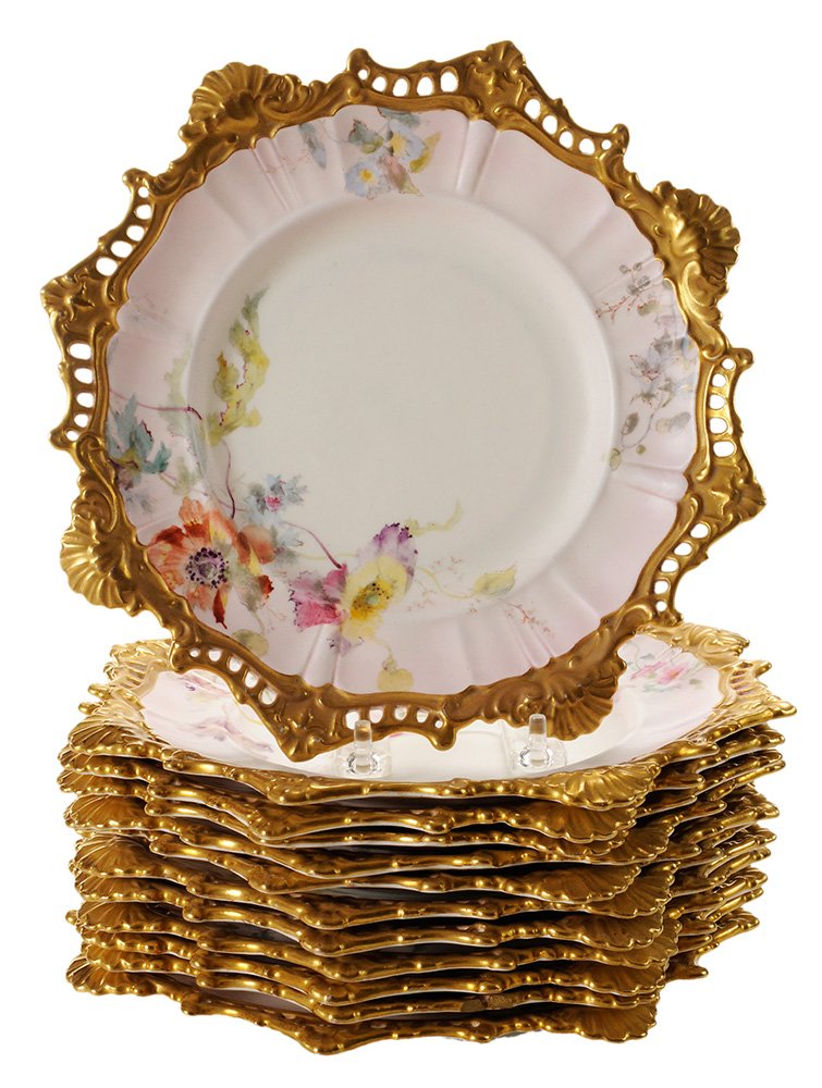 Twelve Doulton Dessert Porcelain: Plates molded in Rococo shape with pierced rim, printed and painted with assymmetrical sprays of various flowers, heavily gilded rim, signed with crowned Doulton/Burslem backstamp in brown, stamped in