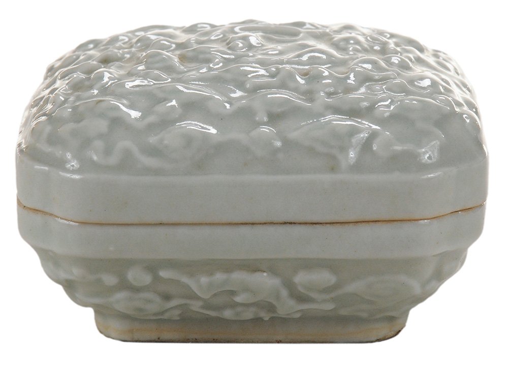 Molded White Celadon-Glazed Porcelain: Covered Box Chinese, cover with Qilong surrounded by bats and clouds, tapering base with bats, square platform base, white interior, 3 in. square good condition. Provenance: Estate of Michael Lawrence