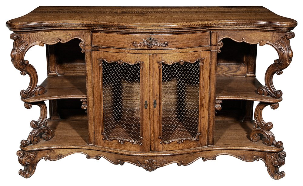 Finely Carved Provincial Oak Bow-: Front Sideboard French, late 19th century, shaped thumb-molded overhung top over a single drawer and two grillwork doors flanked by two-tiered shelves with scrolling supports at the front, shaped flor