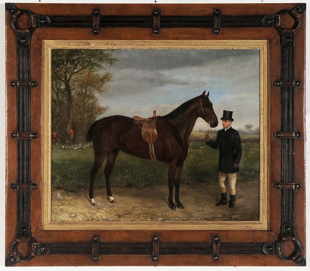 British School: (19th century) Hunter and Owner Resting from the Hunt, signed indistinctly lower right "W.H. Wh..?", oil on canvas, 20-1/4 x 24-1/4 in.; fine and interesting leather, wood and horse tack frame,. Condi