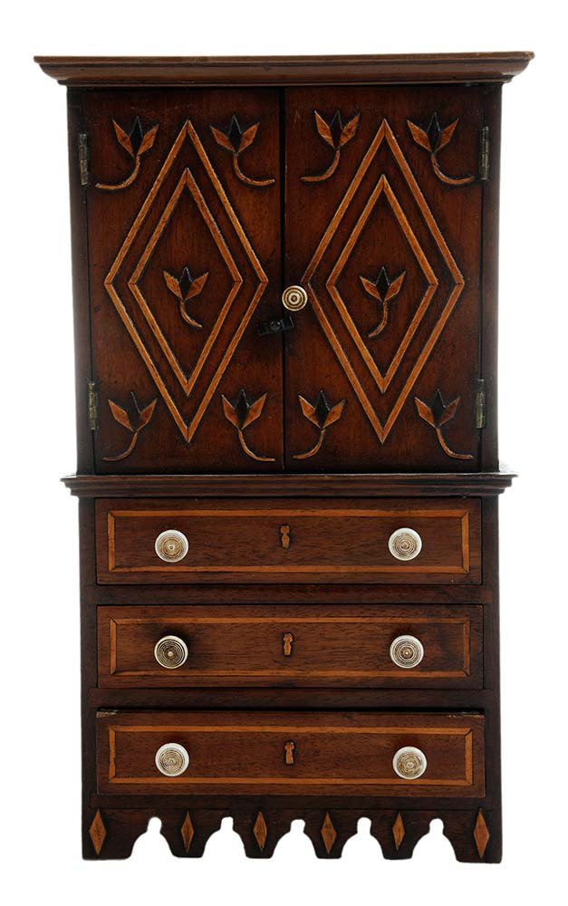 George III Hepplewhite Style Miniature: Linen Press English, 19th century, molded cornice over two doors with applied diamond-shaped panels and stylized flowers over three graduated drawers with line inlay, shelved interior, scalloped skirt