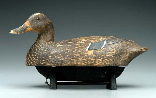 Dan Schmidt mallard hen decoy,: slightly turned head, carved feather detail, bottom branded "DS", Royal Oak, Michigan, wooden stand, 16-1/2 in. Original paint with scattered abrasions and losses. Provenance: Bob Timberlake Collectio