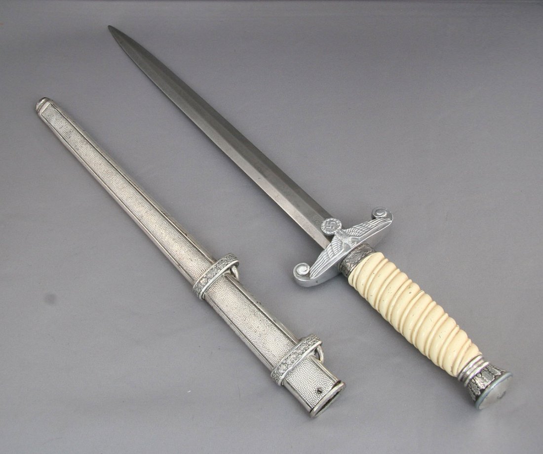 A German Third Reich Navy officer's dagger of: A German Third Reich Navy officer's dagger of regulation design with double edged blade, impressed "Solingen", in original sheath with suspension rings.