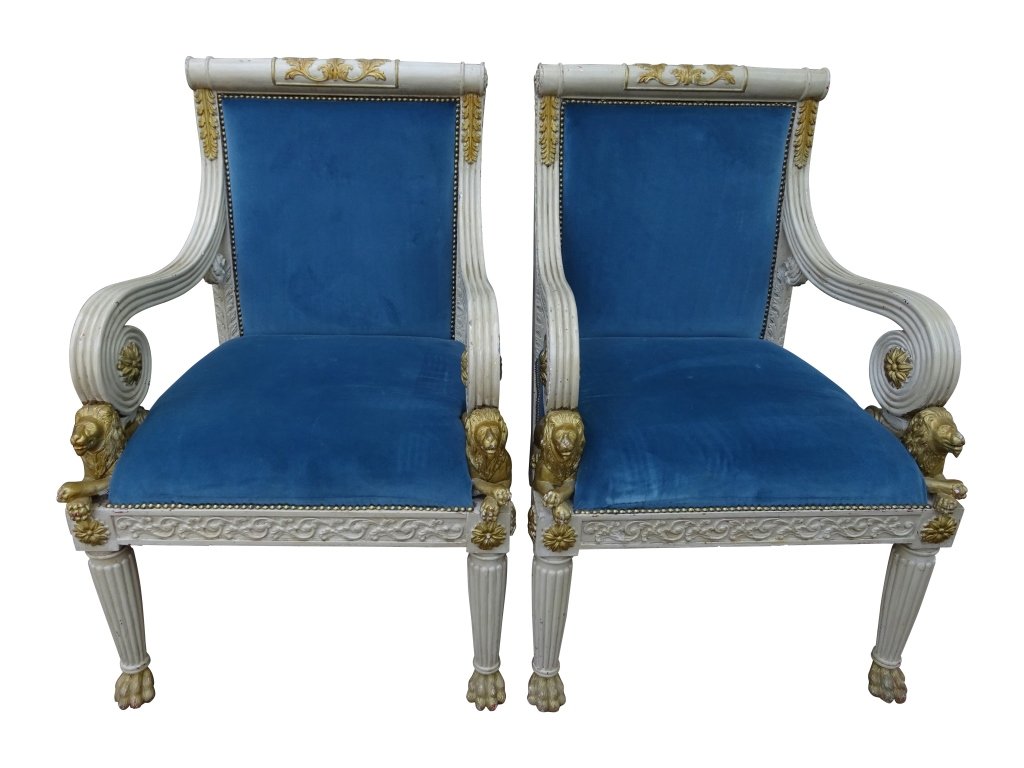 REGENCY STYLE:: Pair of Lion motif arm chairs,Gilt and painted with recumbant lions Measures 38 inches in height by 25 inches in width by 26 inches in depth by 17 inches in seat height.