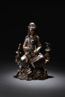 Chinese Gilt Bronze Bodhisattva Statue: Gilt gold bronze guanyin statue wearing a loose and voluminous robe and beaded necklace sitting casually on a lotus throne holding a child in front of her lap. There is a bottle and a bird on her righ