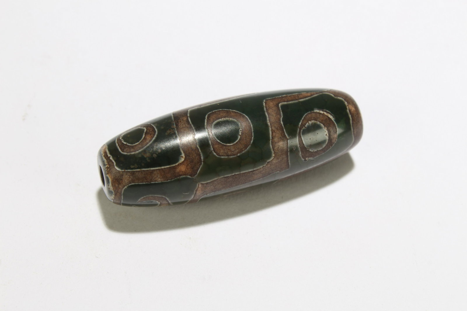 A Tibetan Dzi Bead: A Tibetan Dzi Bead . Length: 1.75 (inch).