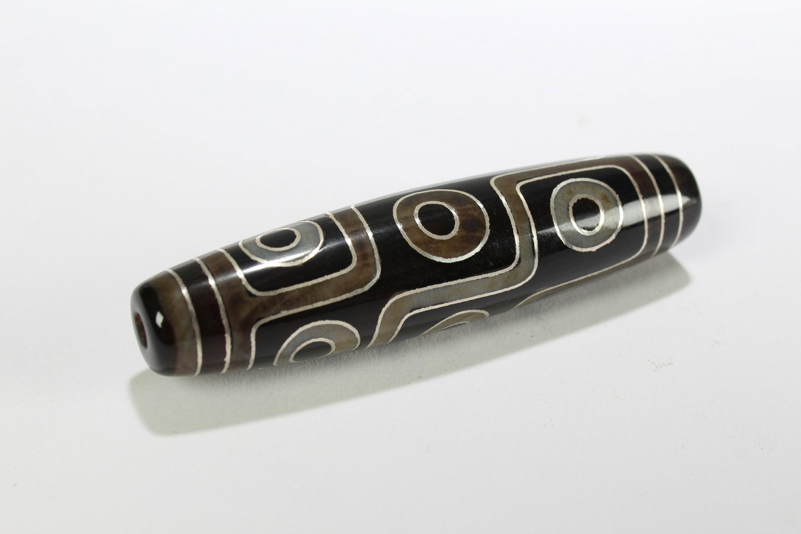 A Tibetan Religious Dzi Bead: A Tibetan Religious Dzi Bead . Length: 2.75 (inch).