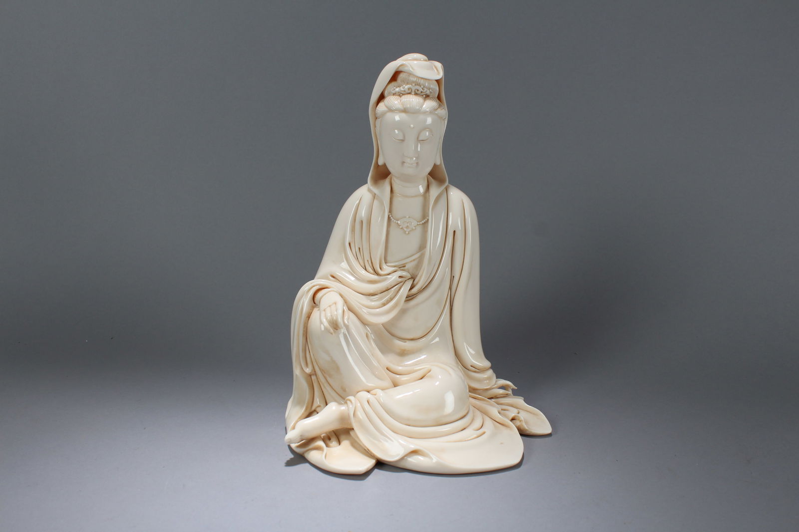 A Chinese De Blac Vividly-detailed Porcelain Fortune Guanyin Statue: A Chinese De Blac Vividly-detailed Porcelain Fortune Guanyin Statue. Height: 12.25 (inch). Width: 8.5 (inch). Length: 7.75 (inch)