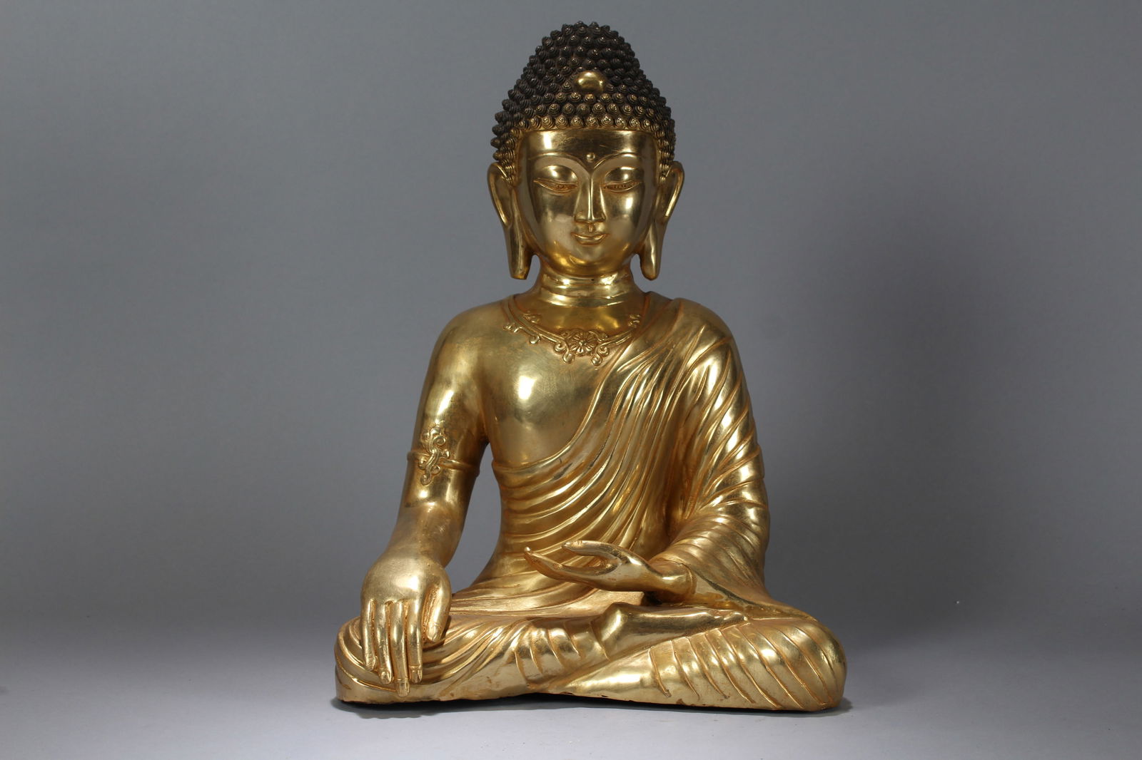 A Chinese Vividly-detailed Religious Massive Gilt Buddha Statue: A Chinese Vividly-detailed Religious Massive Gilt Buddha Statue. Height: 16.5 (inch). Width: 9 (inch). Length: 12 (inch).