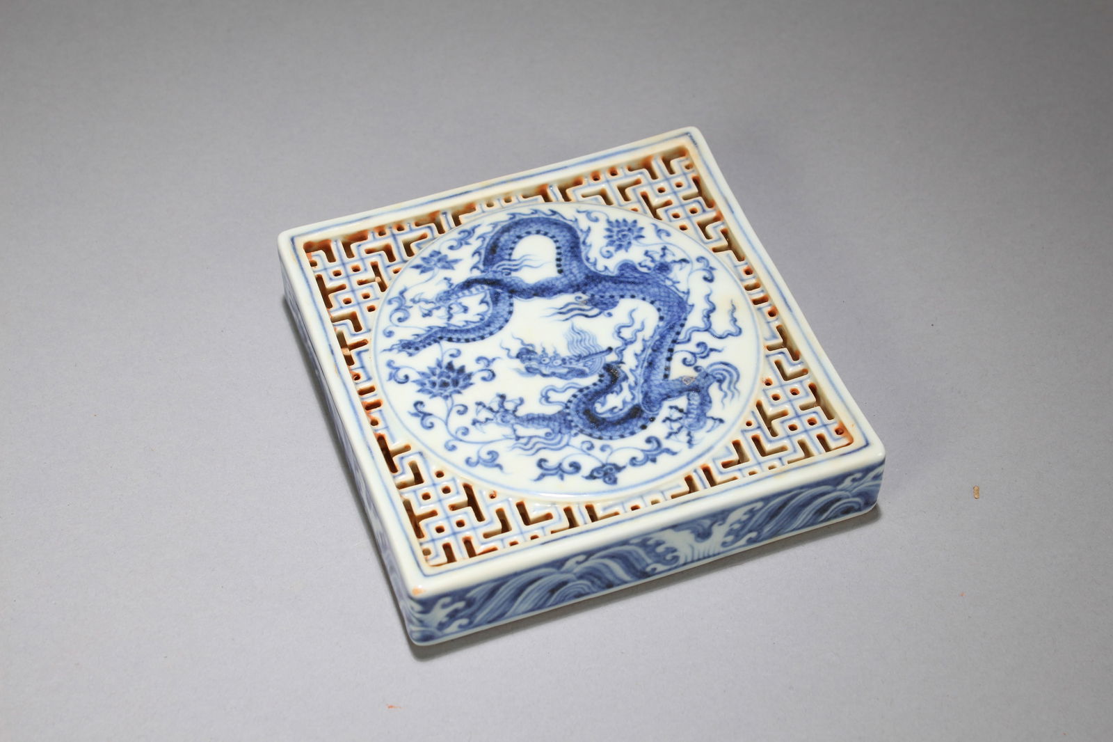 A Chinese Blue and White Square-based Porcelain Dragon-decorating Fortune Plate: A Chinese Blue and White Square-based Porcelain Dragon-decorating Fortune Plate. Height: 1 (inch). Length: 4.75 (inch). Width: 4.75 (inch).