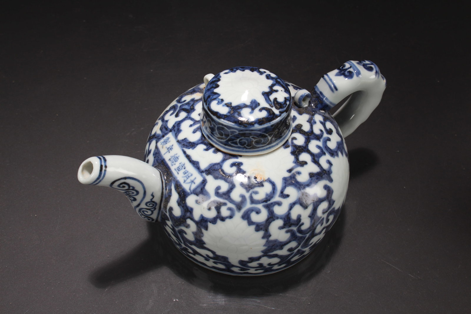 A Chinese Blue and White Porcelain Fortune Tea Pot: A Chinese Coin-filled Lidded Wooden Box. Height: 5 (inch). Length: 9 (inch).