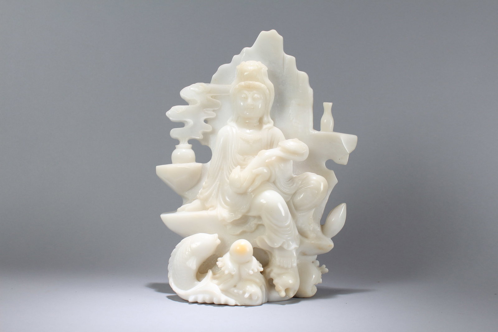 A Chinese Massive Religious Jade-curcing Vividly-detailed Fortune Guanyin Statue: A Chinese Massive Religious Jade-curcing Vividly-detailed Fortune Guanyin Statue. Height: 14.5 (inch). Length: 11 (inch). Width: 5 (inch).