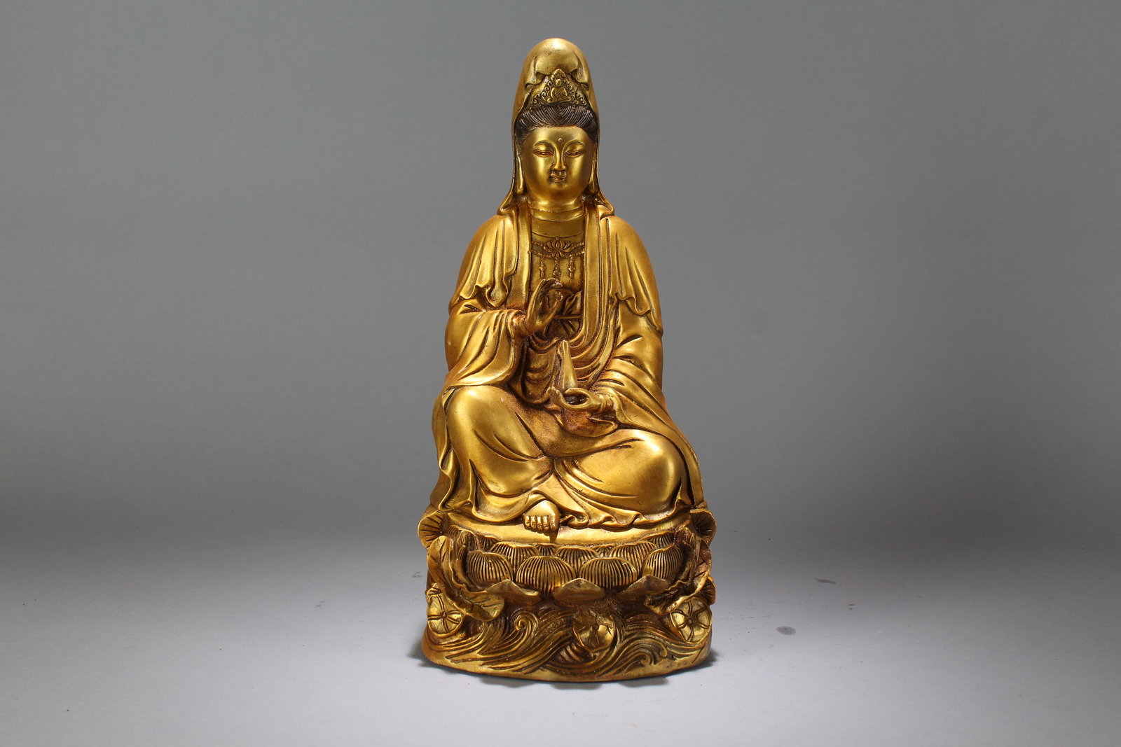 A Chinese Gilt Fortune Guanyin Buddha Statue: A Chinese Gilt Fortune Guanyin Buddha Statue. Height: 13.5 (inch). Width: 6.5 (inch). Length: 5 (inch).