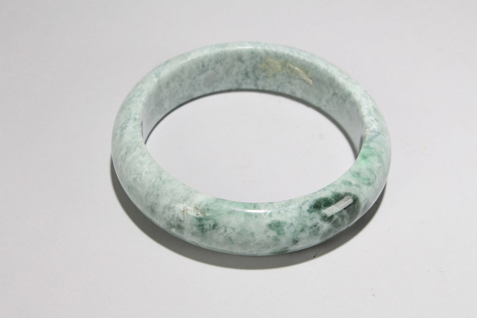 A Chinese Jade-curving Bangle: A Chinese Jade-curving Bangle. Opening Diameter: 3.25 (inch).