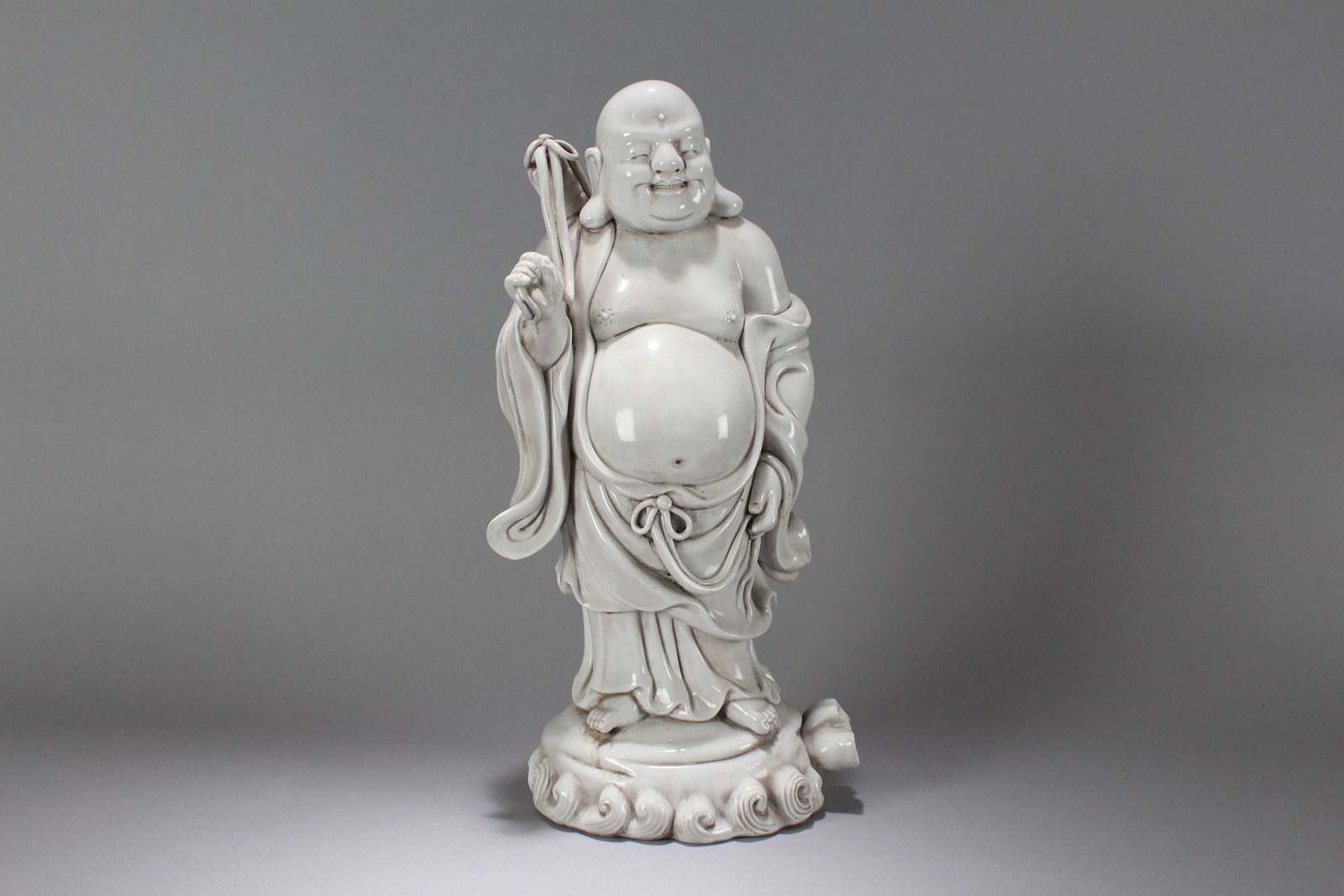 A Chinese Massive Vividly-detailed De Blac Porcelain Happy-Buddha Statue: A Chinese Massive Vividly-detailed De Blac Porcelain Happy-Buddha Statue. Height: 15.5 (inch). Width: 6.75 (inch). Length: 5.75 (inch).